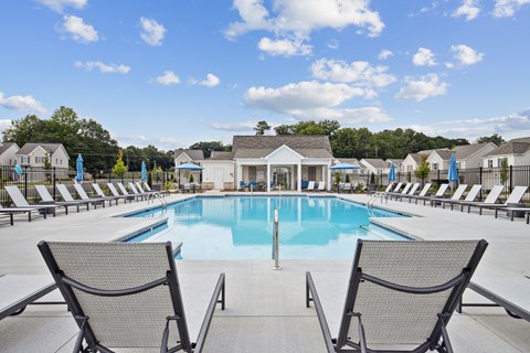 Resort-style pool with lounge seating and a scenic backdrop.