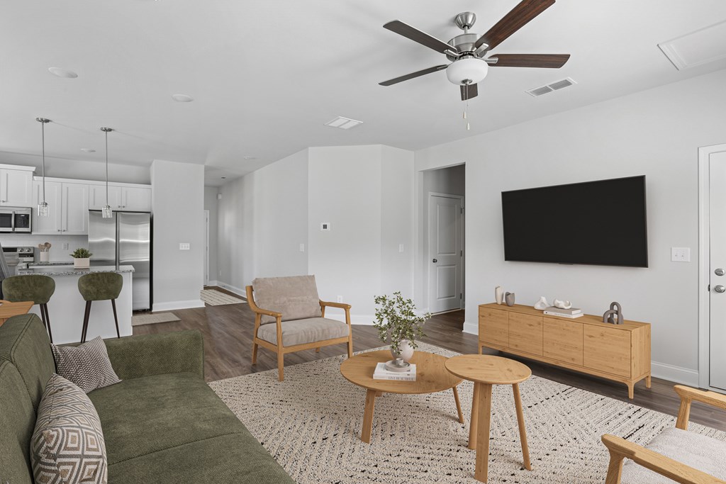 Spacious living room with a plush sectional, modern wood-accent chair, and sleek entertainment center