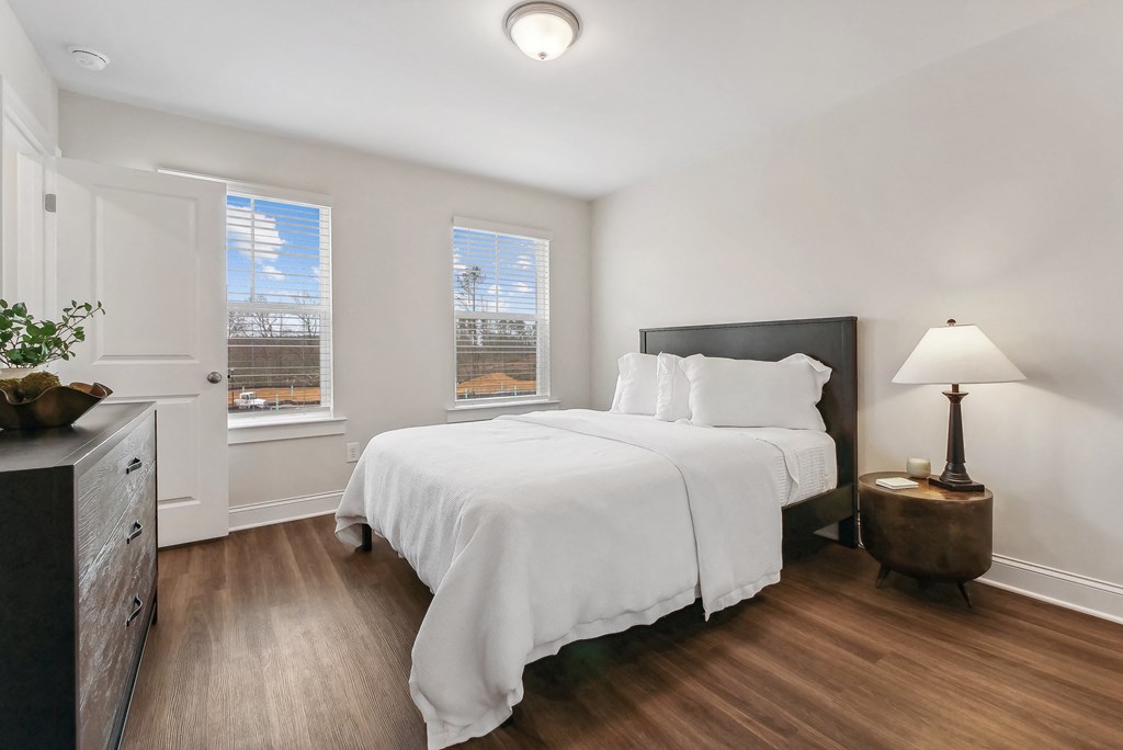 a bedroom with a bed and two windows