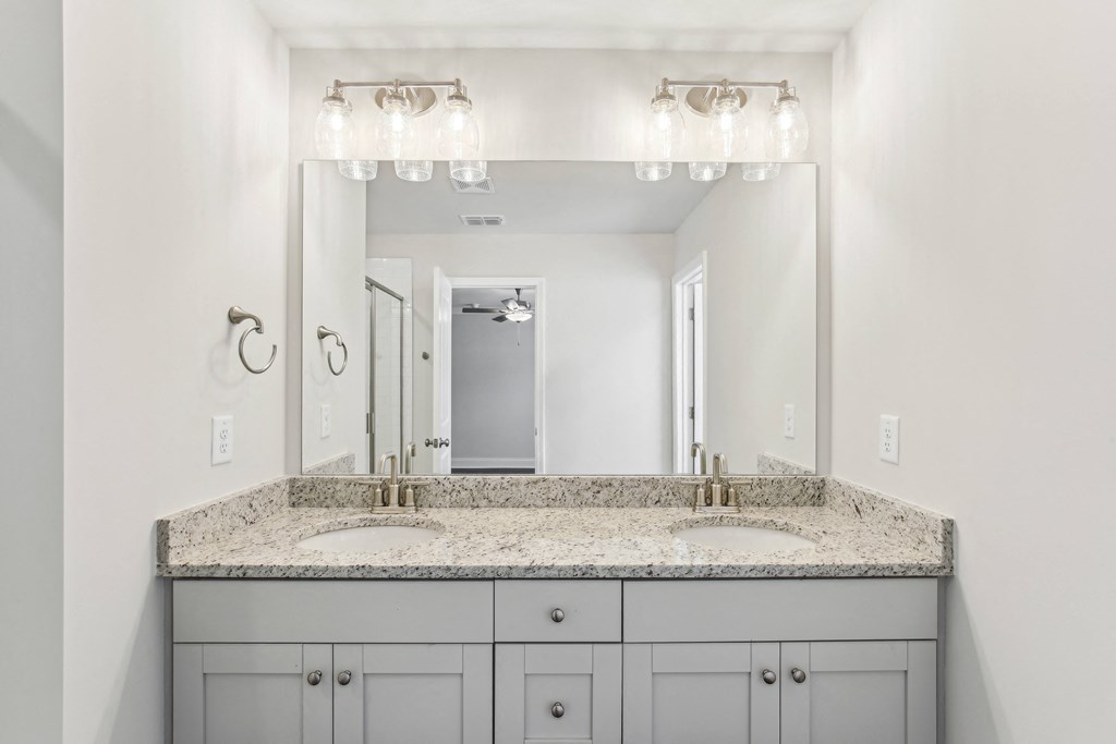 a white bathroom with two sinks and a large mirror