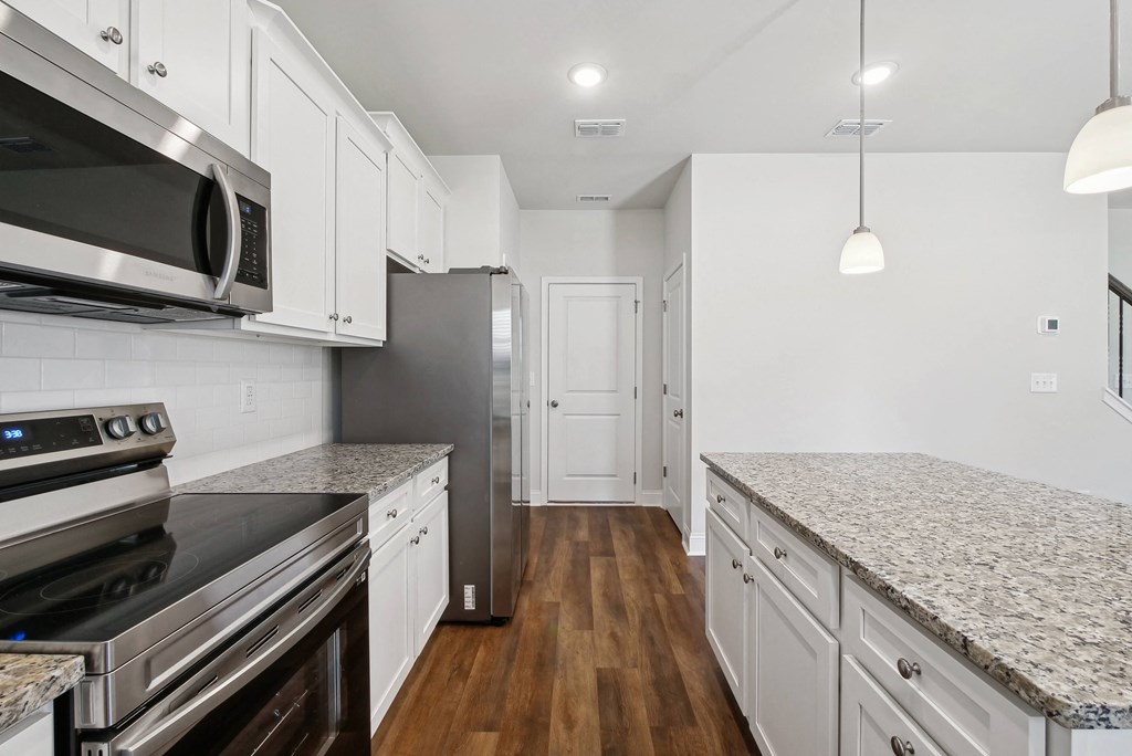 a kitchen with marble counter tops and white cabinets