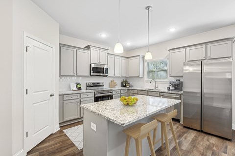 A kitchen with a white counter top and stainless steel appliances.