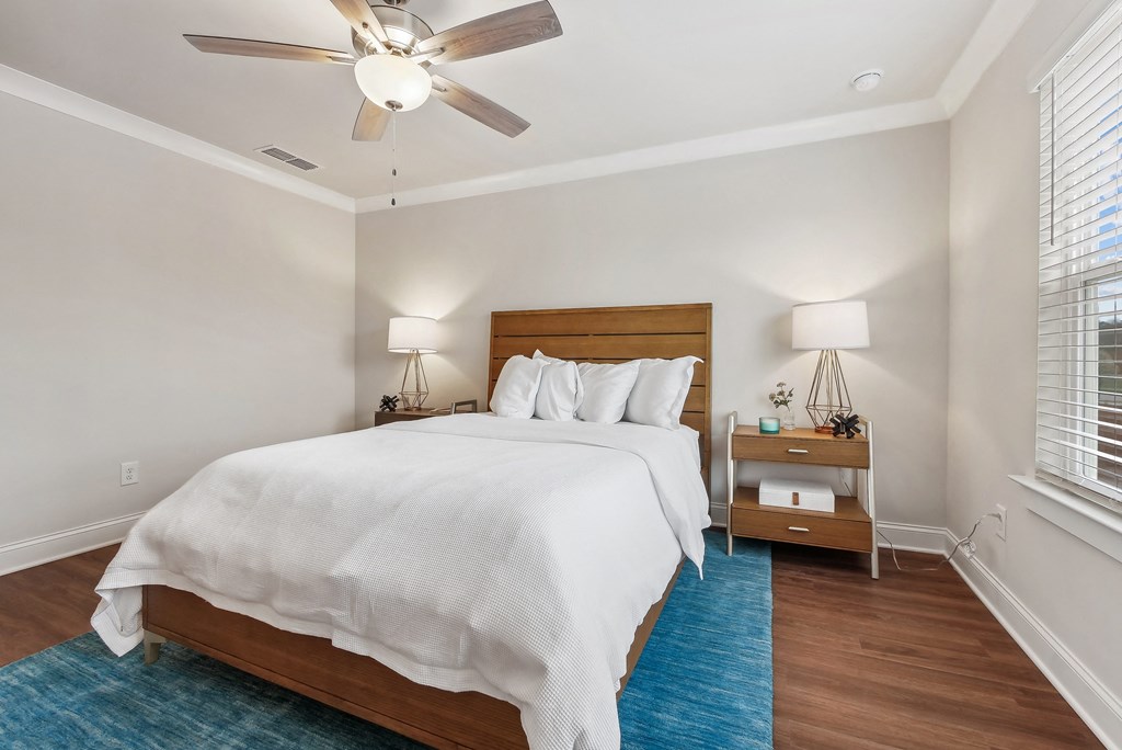a bedroom with a large bed and a ceiling fan