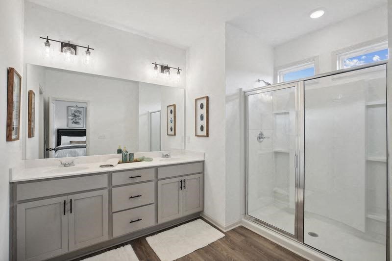 a bathroom with a shower and a sink and a mirror