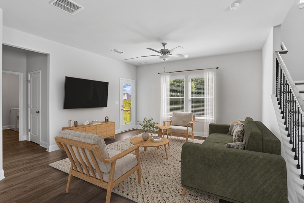 Living room with large couch, accent chairs, and windows.