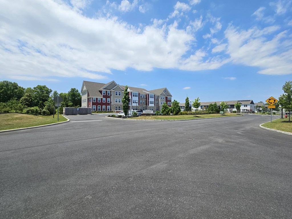 an empty street with an apartment building in the background
