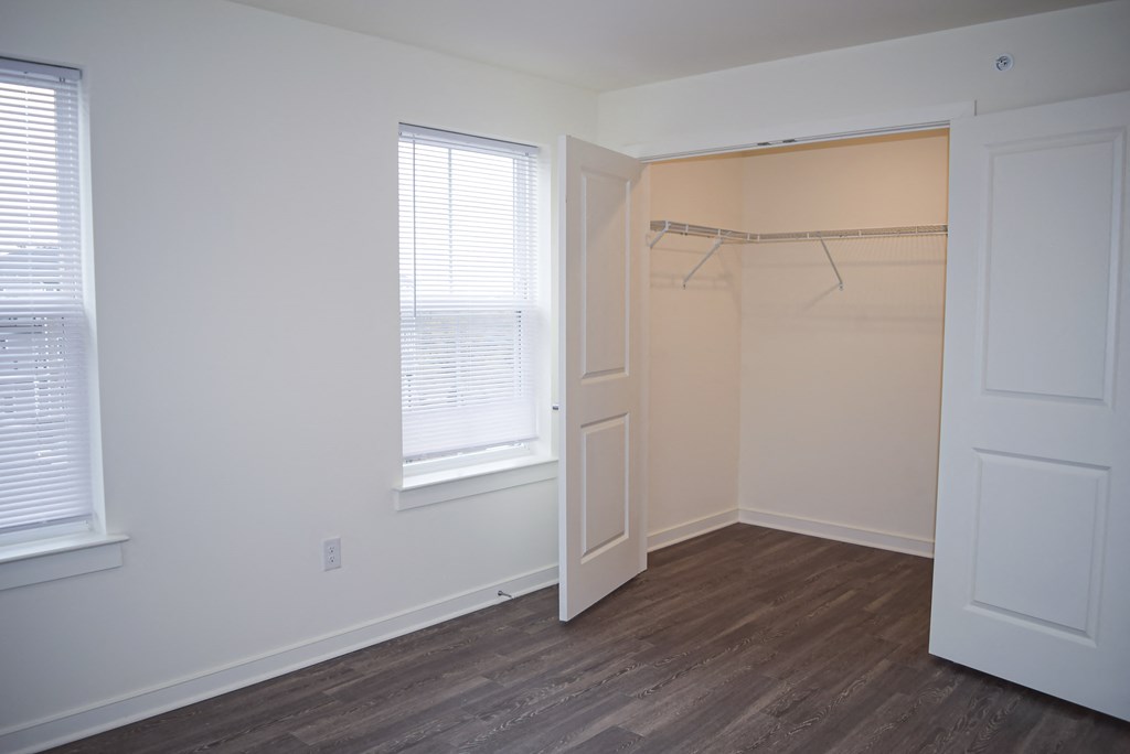 an empty bedroom with a closet and a window