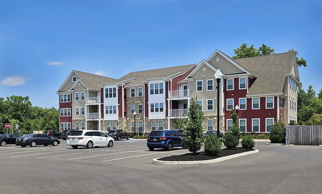 a parking lot with cars in front of an apartment building