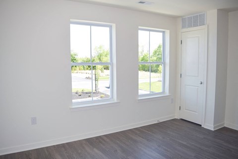 a living room with three windows and a door