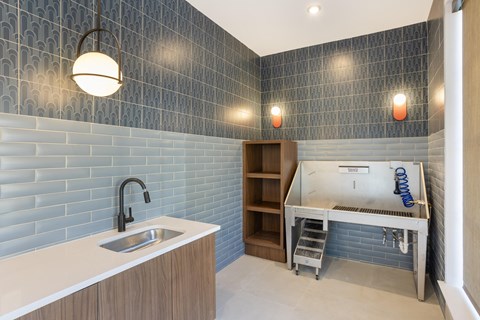 a small kitchen with a sink and a counter top and blue tiles