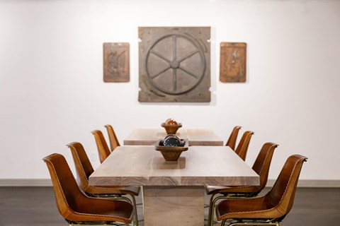 a dining room with a table and chairs and paintings on the wall