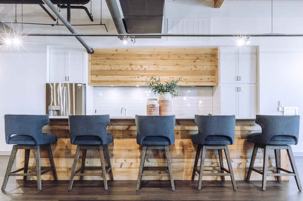 a kitchen with a long table with blue chairs at The Mill at Prattville, Prattville, 36067