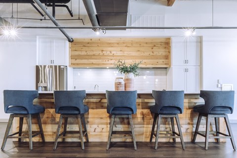 a kitchen with a long table with blue chairs at The Mill at Prattville, Prattville, 36067