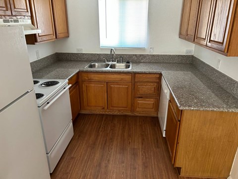 A kitchen with wooden cabinets and a white refrigerator.