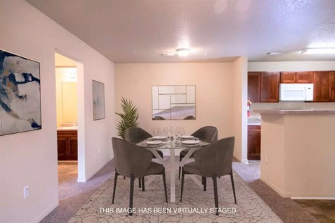 A dining room with a table set for four.