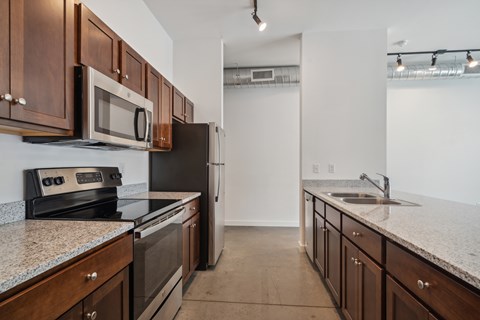 A kitchen with brown cabinets and a black refrigerator.