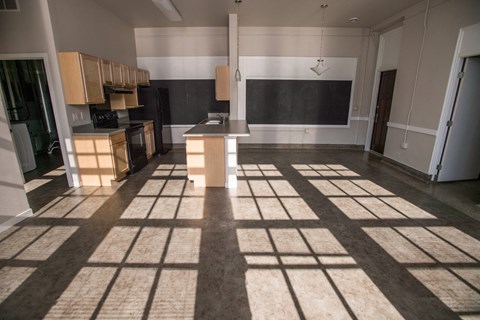 A kitchen with a blackboard on the wall and a tiled floor.