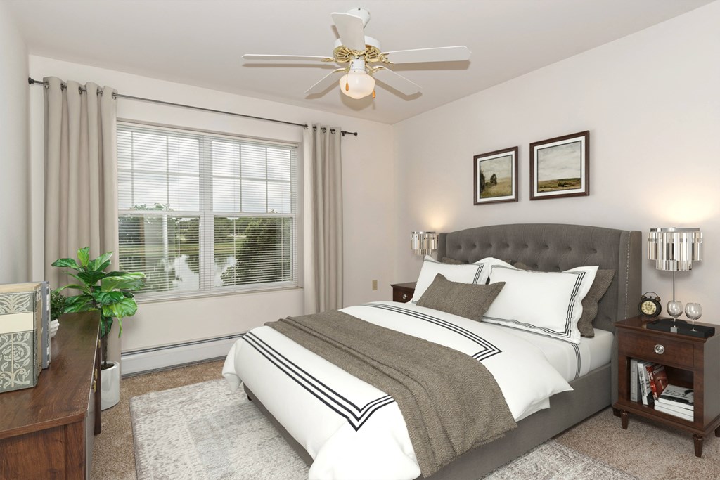 A bedroom with a large bed and a ceiling fan.