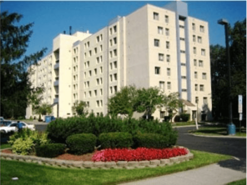 a large white building with a garden in front of it