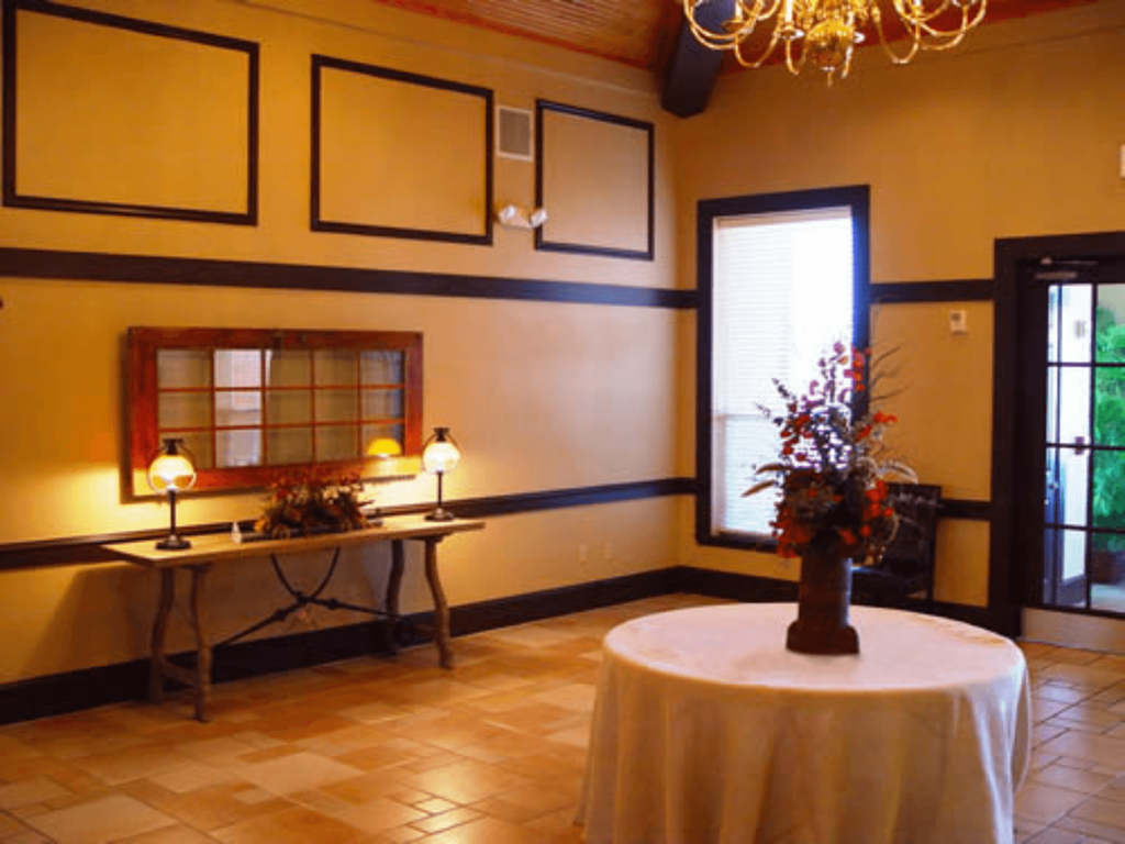 a dining room with a table and a vase with flowers