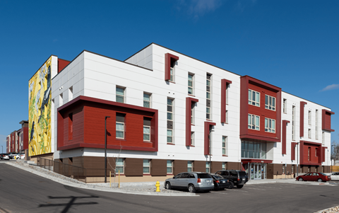 a large red and white building with cars parked in front of it