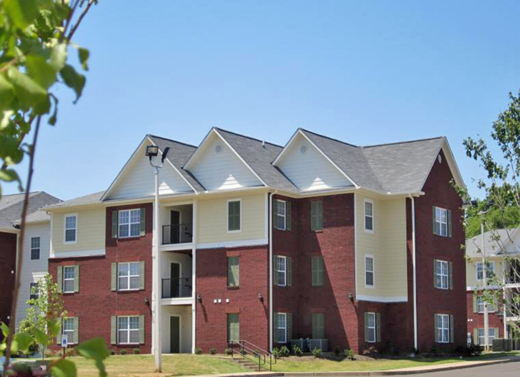 an apartment building with red brick and white columns