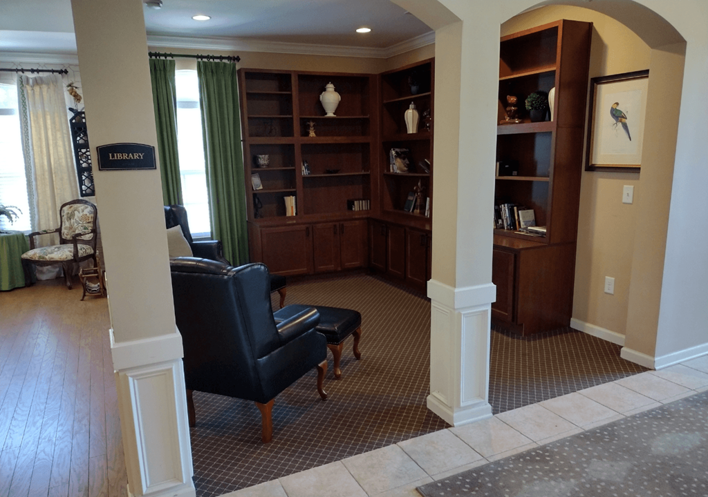 a living room with a couch and a chair and a book shelf