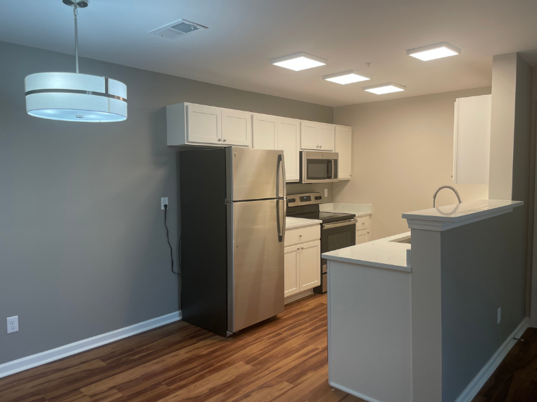 a kitchen with white cabinets and a black refrigerator