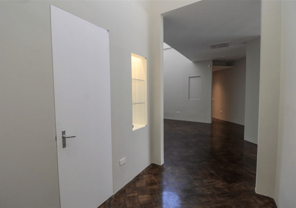 A hallway with a white door and a brown floor.