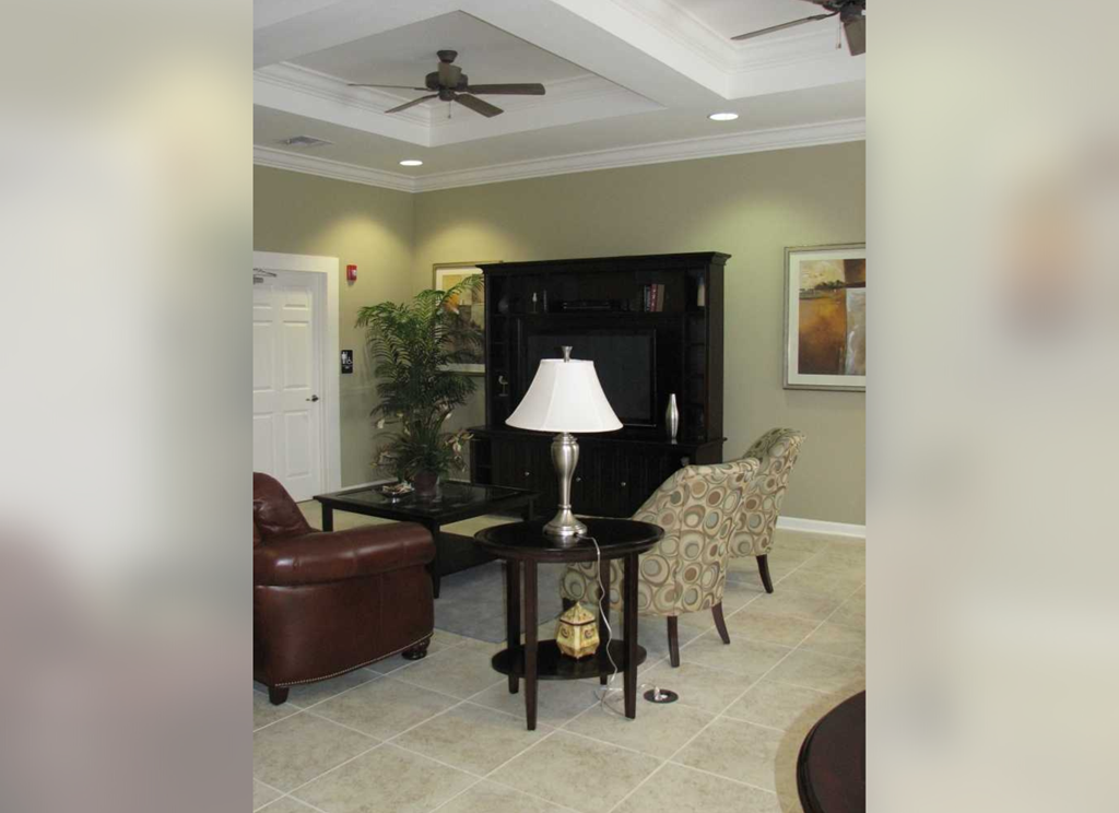 a living room with a table and chairs and a ceiling fan