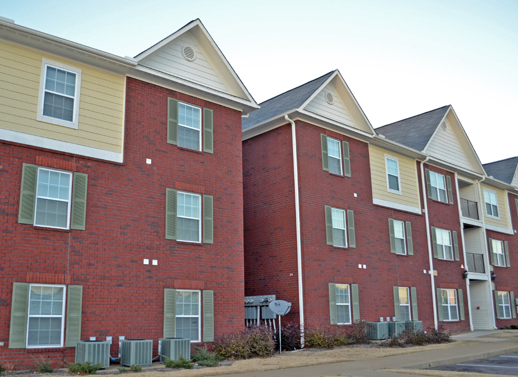 a row of brick apartment buildings on the side of a street
