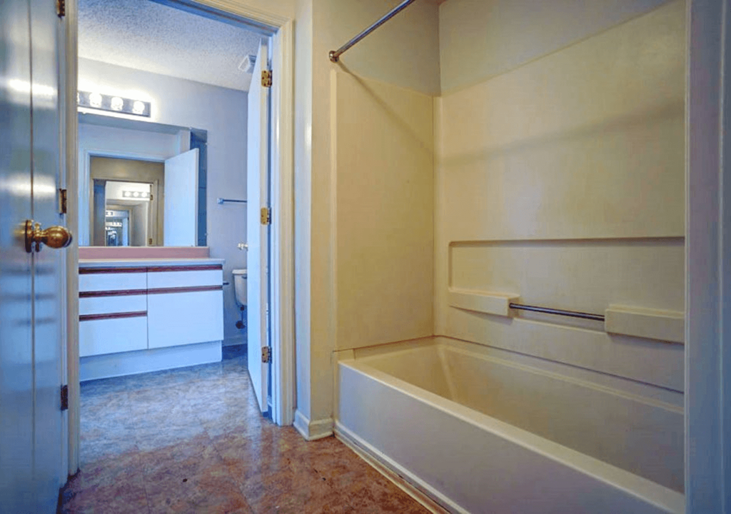 a bath room with a tub and a closet