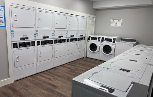 a washer and dryer room in a building with a bunch of white machines