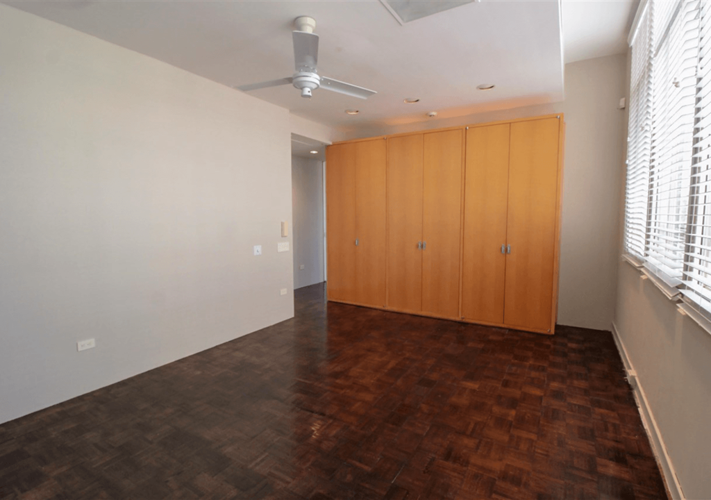 A room with wooden floors and a ceiling fan.