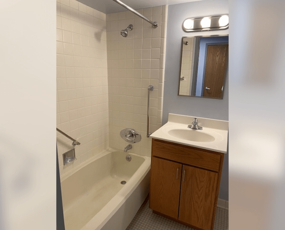 a bathroom with a sink and a tub and a mirror