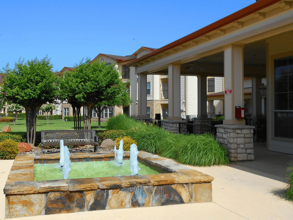 a fountain in front of a building in a courtyard