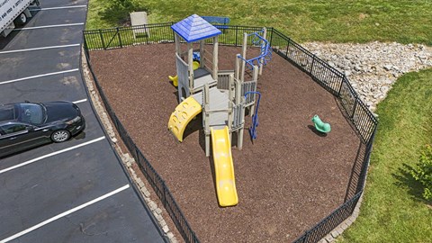 A playground with a yellow slide and a blue roofed structure.