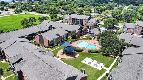 A large building complex with a pool in the middle.