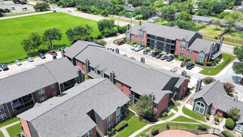 A large building complex with a green lawn in front.