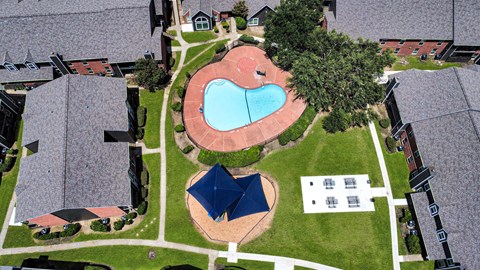 A bird's eye view of a residential area with a swimming pool and a blue pavilion.