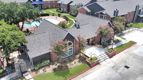 A bird's eye view of a residential area with houses and a swimming pool.