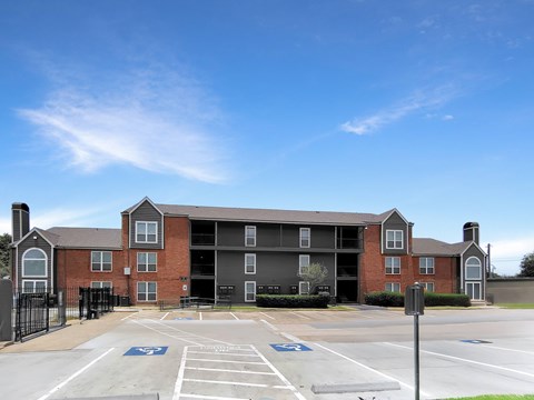 A large brick building with a parking lot in front.