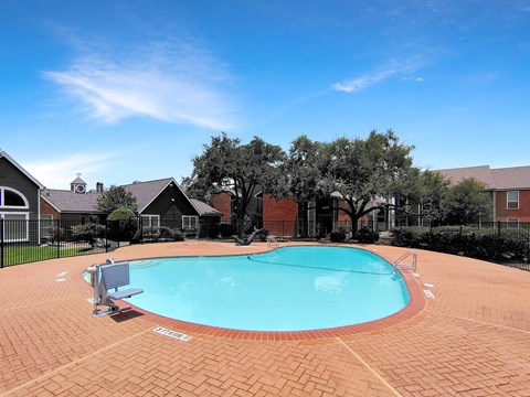 A small pool surrounded by a brick patio.