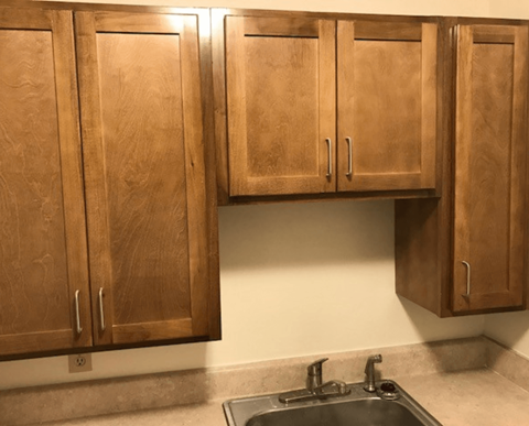 Brown wooden kitchen cabinets above a sink.