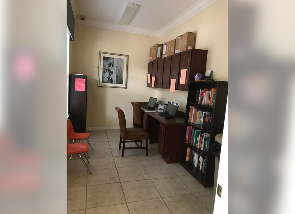 a study room with a desk and chairs and a book shelf
