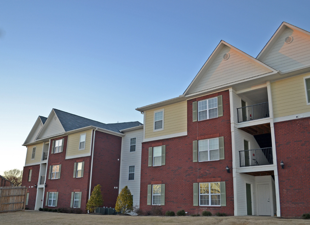 a row of brick apartment buildings with a blue sky in the background