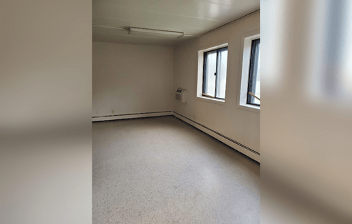 an empty room in a building with two windows