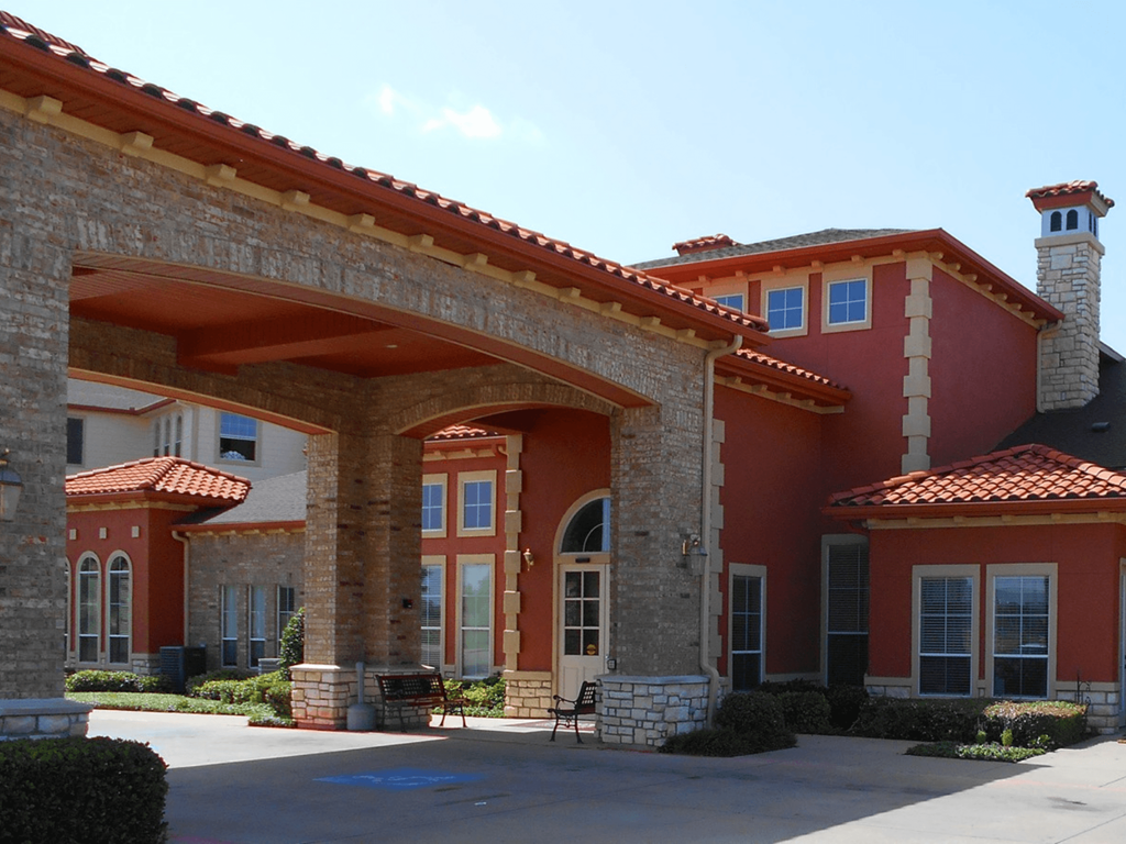 a brick building with an archway and a courtyard