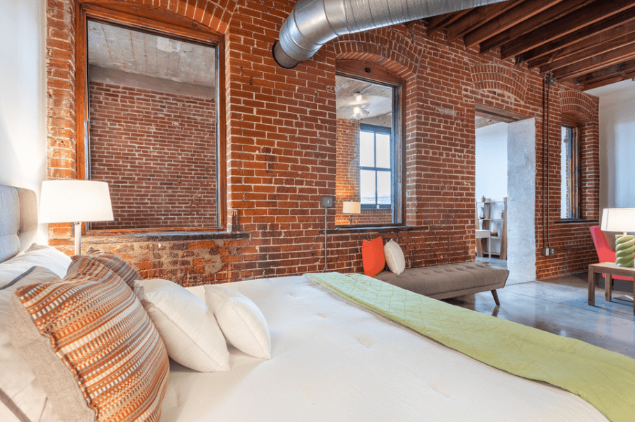 a bedroom with a bed and a brick wall