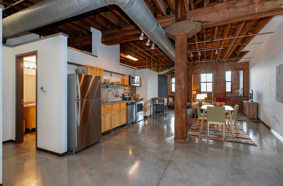 a large kitchen with stainless steel appliances and a dining table